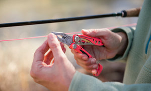 Person using a Guava Skeletool CX pliers to adjust a fishing line.